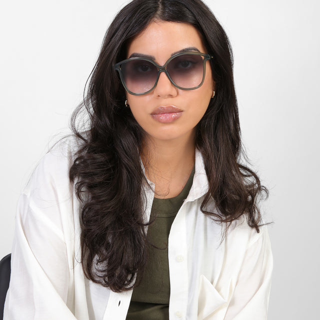 Brunette model in a white blouse wearing Nancy 57 Sunglasses Pine with Grey Gradient