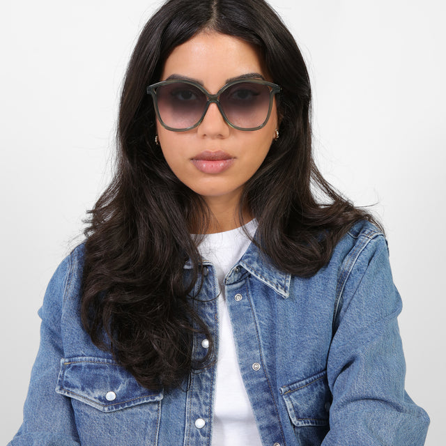 Brunette model in a denim jacket wearing Nancy 57 Sunglasses Pine with Grey Gradient