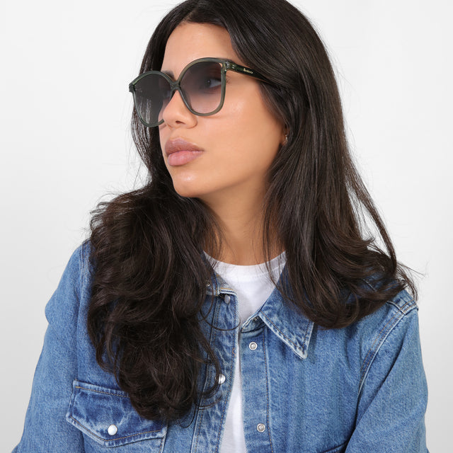 Brunette model in a denim jacket looking right wearing Nancy 57 Sunglasses Pine with Grey Gradient