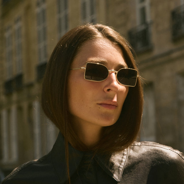 Woman in Paris wearing Nostrand Sunglasses Gold with Grey