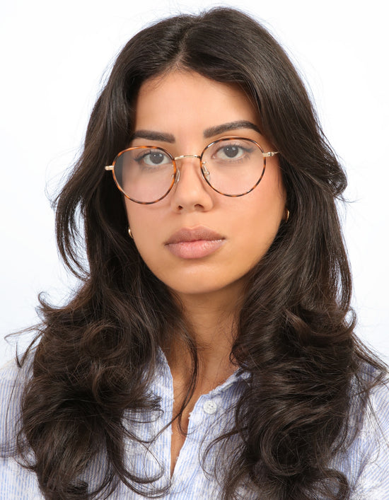 Brunette model with loose curls wearing Oxford 52 in Havana/Gold