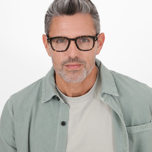 Model with salt and pepper hair wearing Pacific Optical Flame Optical