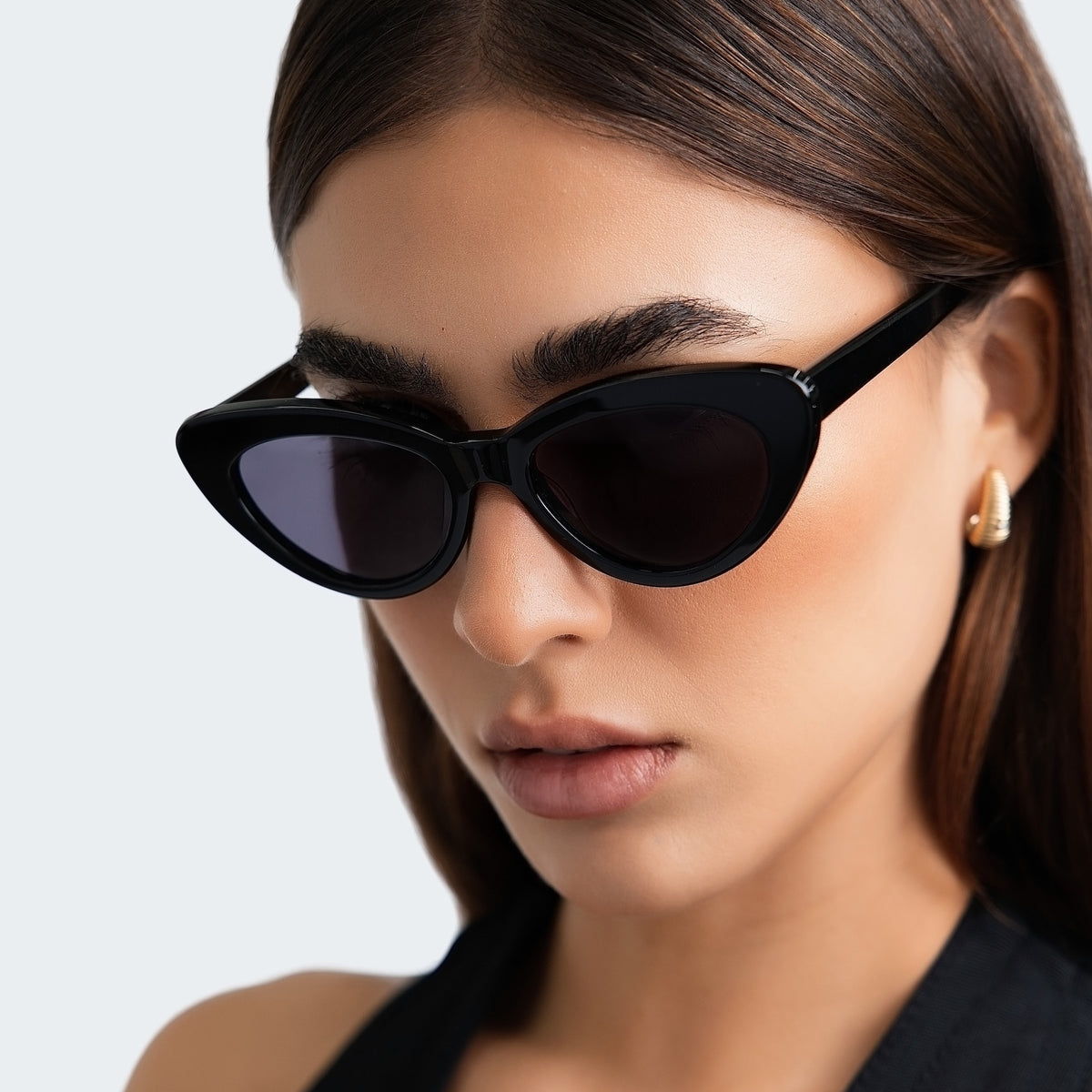 Woman wearing Pamela Sunglasses in Black with Grey Flat lenses, side profile, Woman in a black halter blouse