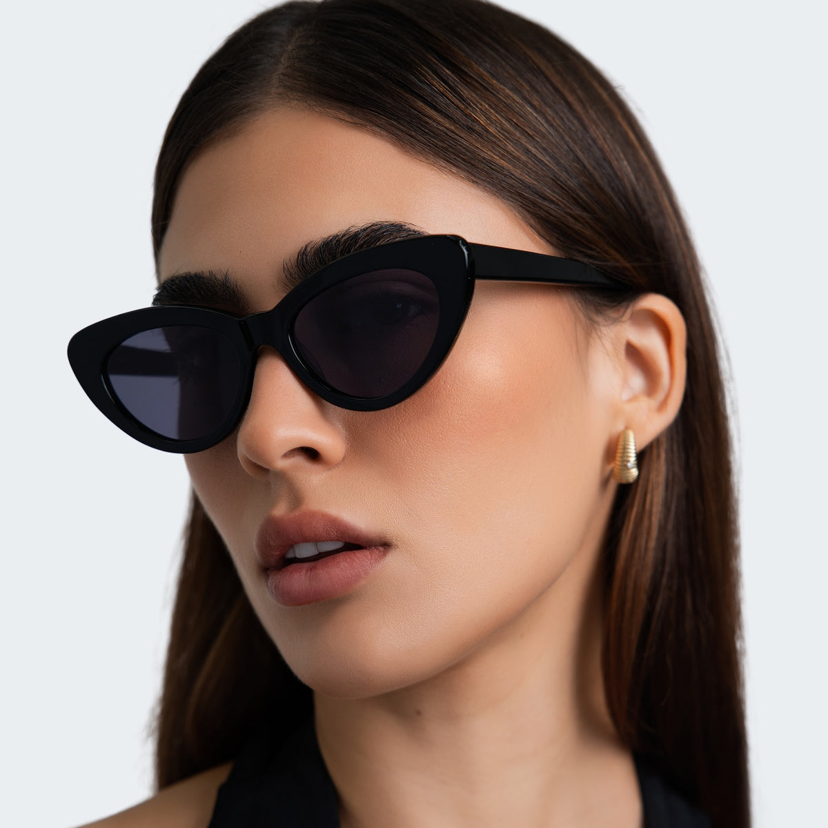 Woman wearing Pamela Sunglasses in Black with Grey Flat lenses, side profile, Close up of woman in a black halter blouse