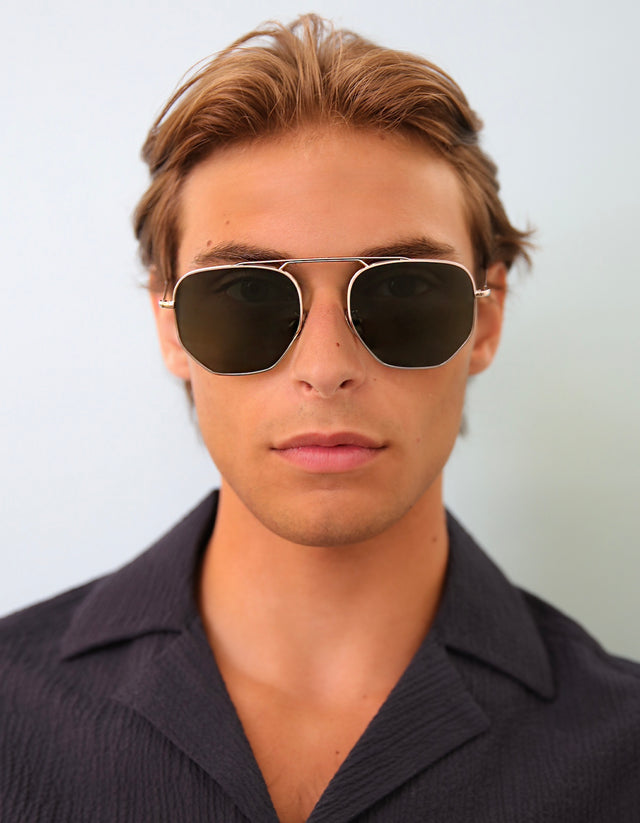 Model with short light brown hair wearing Patmos Sunglasses in Silver with Olive Flat