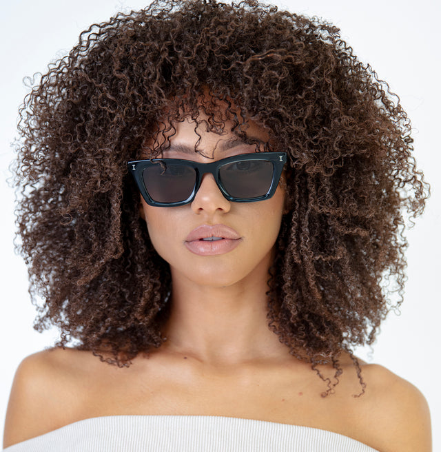 Brunette model with afro-curly hair wearing Portugal Sunglasses Black with Grey Flat