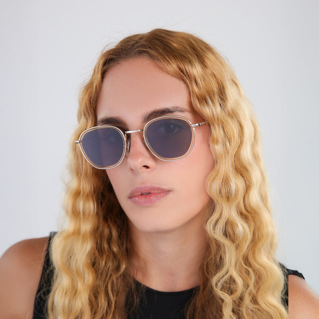 Woman with blond wavy hair in a black blouse wearing Prince Tate Sunglasses Citrine/Gold with Grey Flat