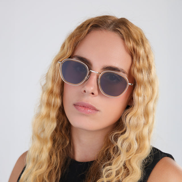 Another angle of woman with blond wavy hair in a black blouse wearing Prince Tate Sunglasses Citrine/Gold with Grey Flat