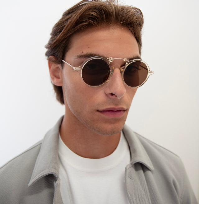 Model with short, brown hair pushed back wearing Roma II Sunglasses Champagne with Brown Flat