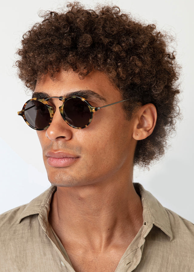 Model with afro-curly hair wearing Roma II Sunglasses Tortoise with Grey Flat