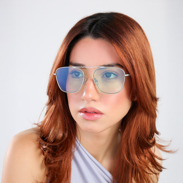 Woman with red hair in a blue blouse looking right wearing Samos Sunglasses Silver with Mint Flat See Through