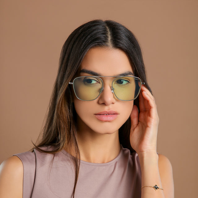 Brunette woman in a clay blouse wearing Samos Sunglasses Silver with Mint Flat See Through