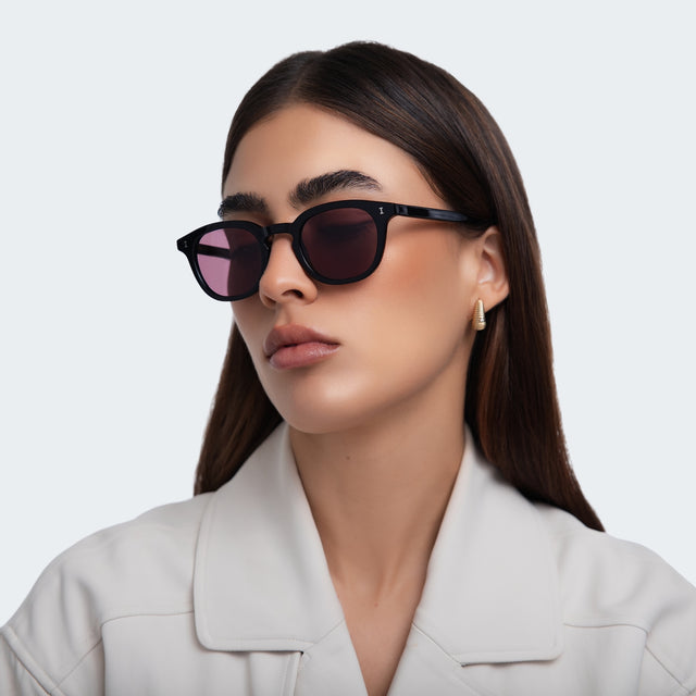 Another angle of woman in a grey blazer wearing Slope Sunglasses Black with Plum See Through