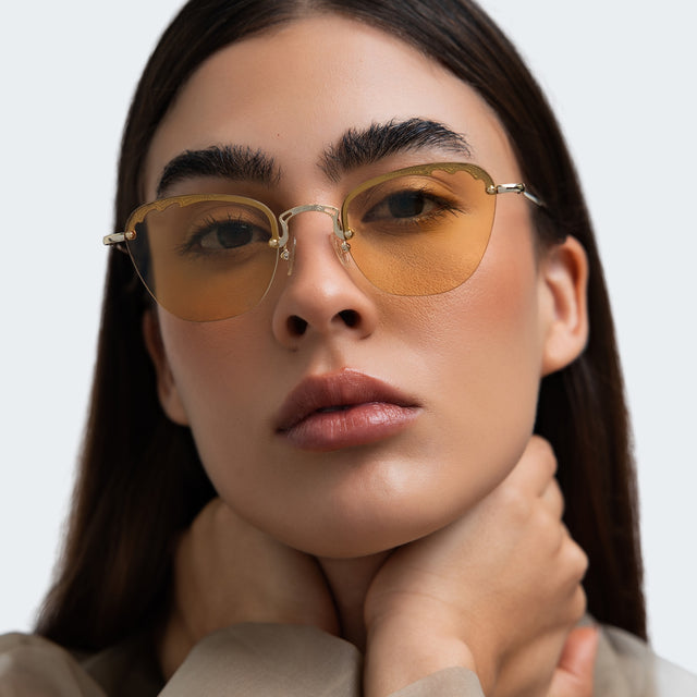 Woman in a beige blouse wearing Sorrento Sunglasses Gold with Honey Flat See Through
