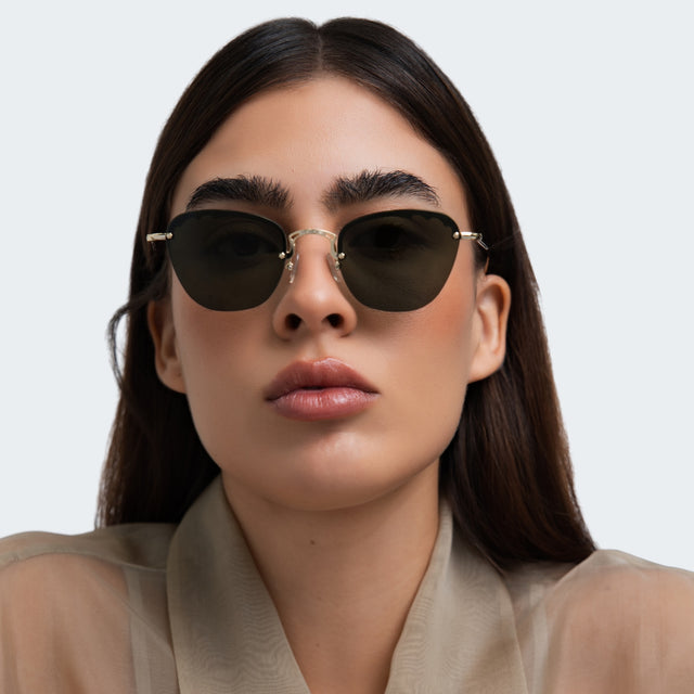 Woman in a beige blouse wearing Sorrento Sunglasses Gold with Olive Flat