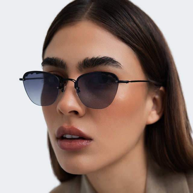 Woman in a beige blouse wearing Sorrento Sunglasses Matte Black with Grey Flat Gradient