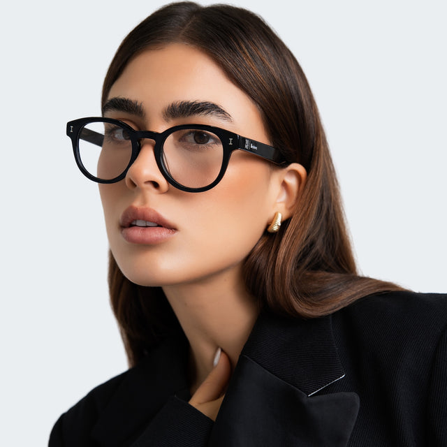 Another angle of woman in a black blazer wearing The Met x illesteva II Optical Black Optical