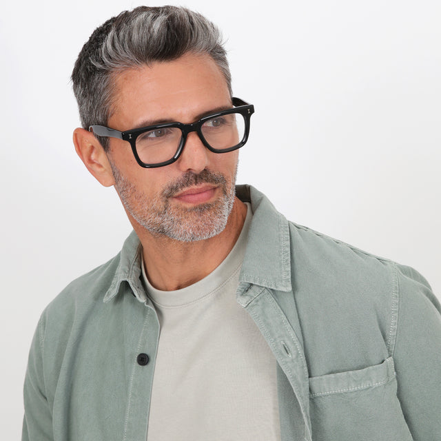 Model with salt and pepper hair and beard wearing Toscana Optical Black Optical