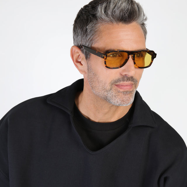 Model with salt and pepper hair and beard looking left wearing Trancoso Sunglasses Star Tortoise with Honey See Through