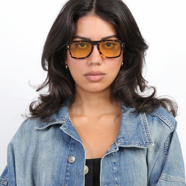 Brunette model with loose curls wearing Trancoso Sunglasses Star Tortoise with Honey See Through