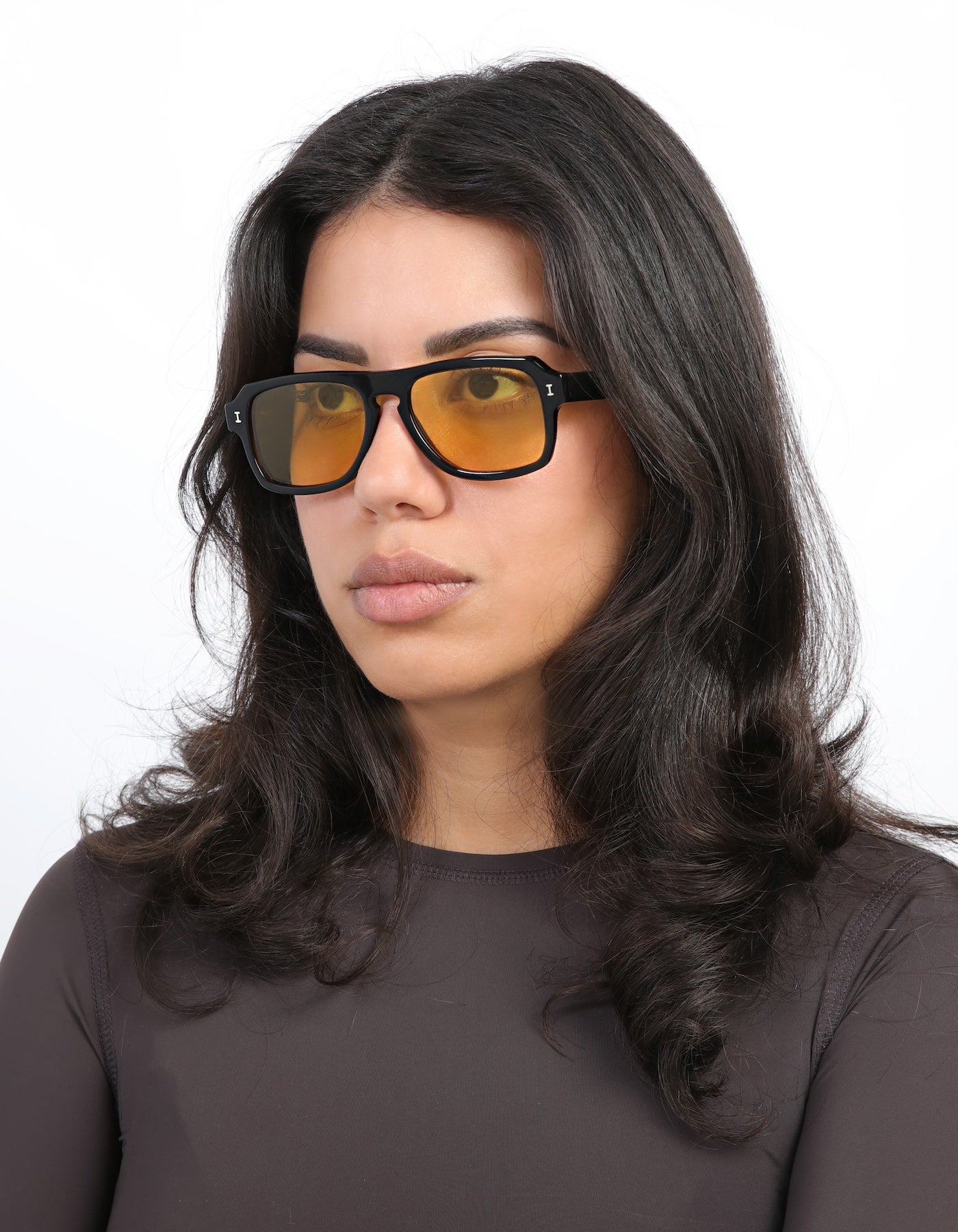 Brunette model wearing Trancoso Sunglasses in Black with Honey