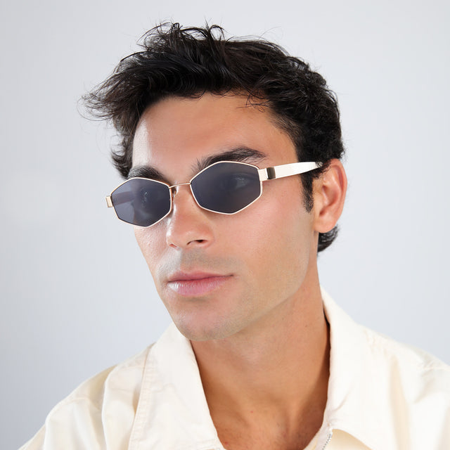 Man in a pale yellow linen shirt wearing Tucson Sunglasses Rose Gold/Cream with Grey