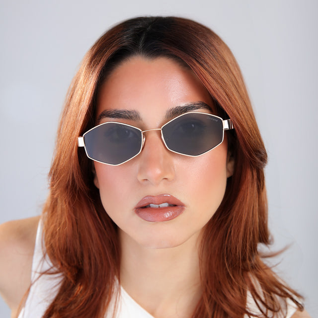 Woman with red hair in a white blouse wearing Tucson Sunglasses Rose Gold/Cream with Grey