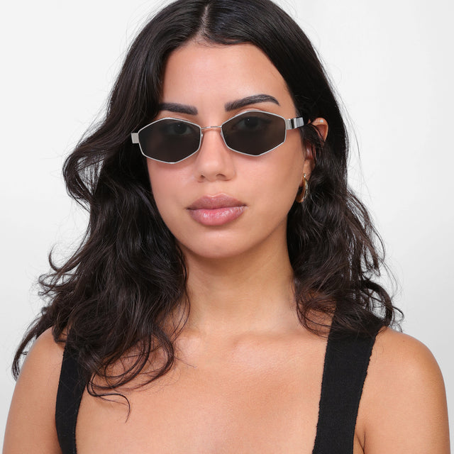 Brunette model with loose curls wearing Tucson Sunglasses Silver/Winter with Grey