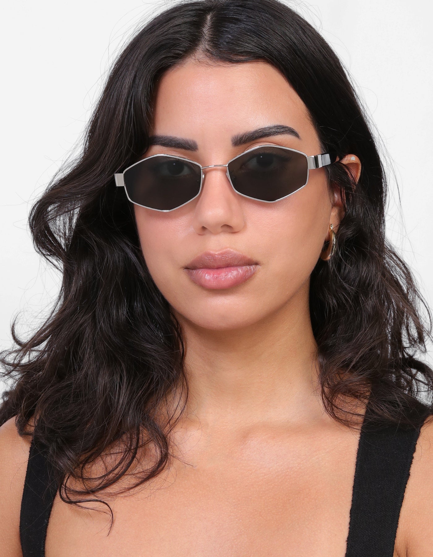 Brunette model with loose curls wearing Tucson Sunglasses in Silver/Winter