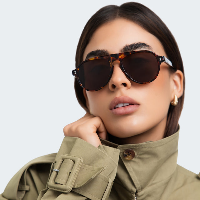 Woman in a trench coat Vanderbilt Sunglasses front view in Star Tortoise with Brown