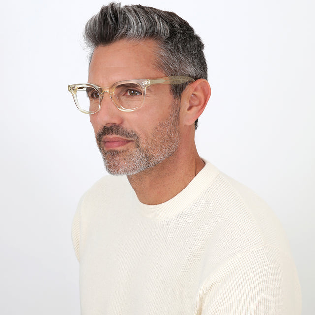 Model with salt and pepper hair and beard wearing Veneto Optical Champagne Optical