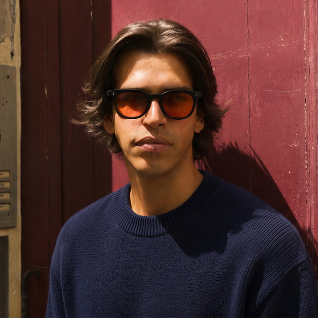 Man in Paris near a red door wearing Veneto Sunglasses Black with Sunset Flat