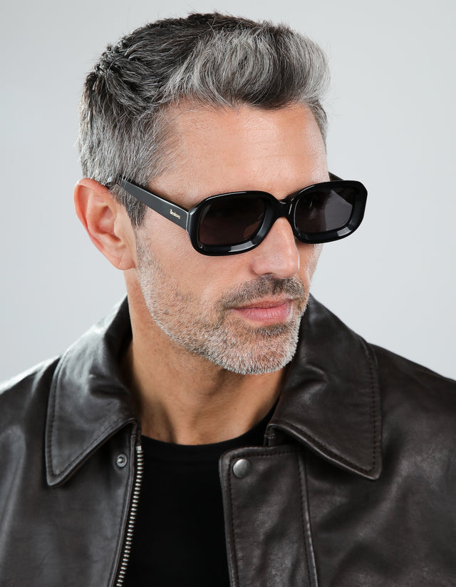 Man in a leather jacket wearing the Vinyl sunglasses in black