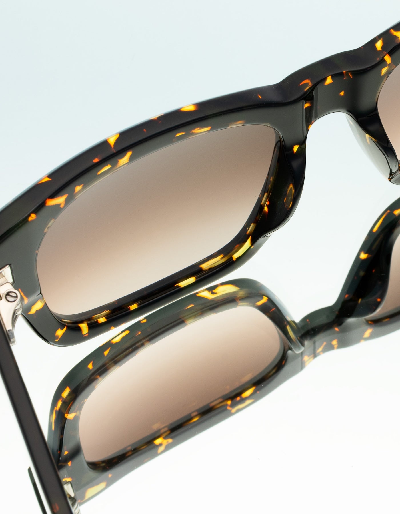 Close up of Vito Sunglasses in Flame with brown gradient lenses on a mirror