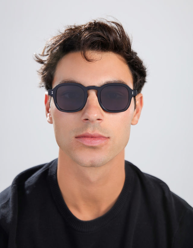 Man in a black tee wearing the Washington Sunglasses in Black