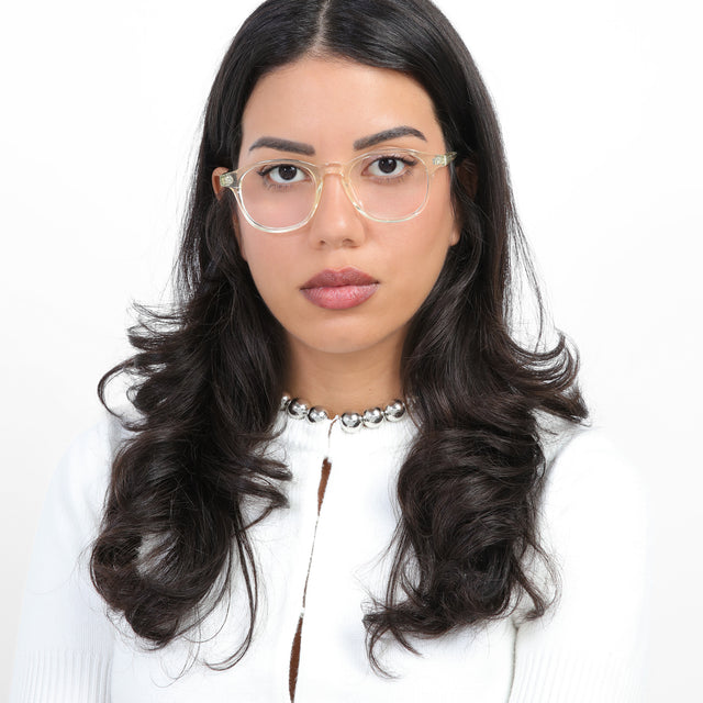 Woman in a white knit cardigan with a pearl necklace on wearing Whitman Optical Champagne Optical