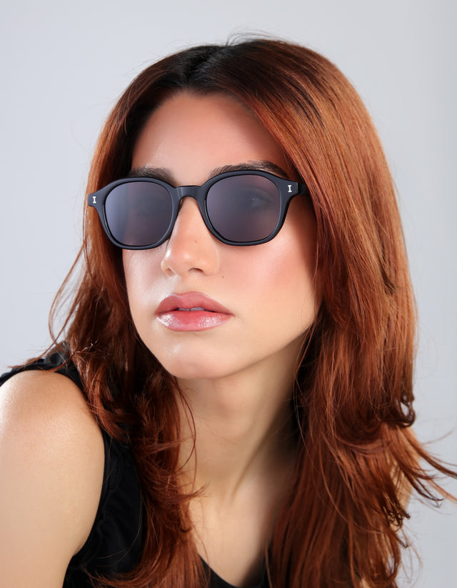 Woman with red hair wearing the William sunglasses in black