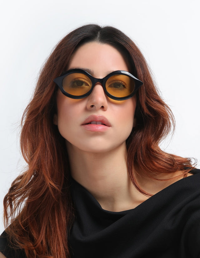Woman with red hair wearing the Willow Sunglasses with Honey See Through lenses