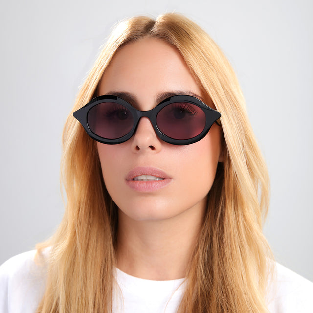 Blond woman in a white tee with straight hair wearing Willow Sunglasses Black with Plum See Through