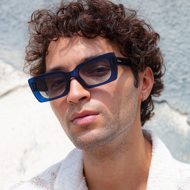 Male model with short curls wearing Wilson II Sunglasses Navy with Grey Flat Gradient