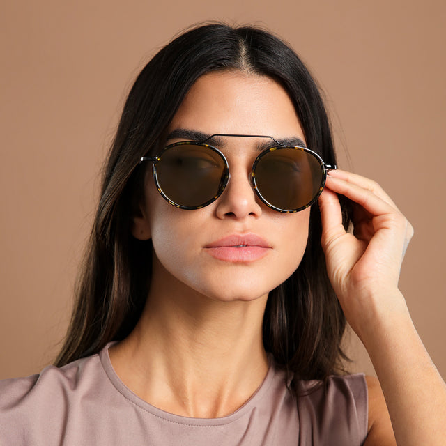 Brunette in a clay mock neck blouse wearing Wynwood Ace Sunglasses Flame/Black with Gold Flat Mirror