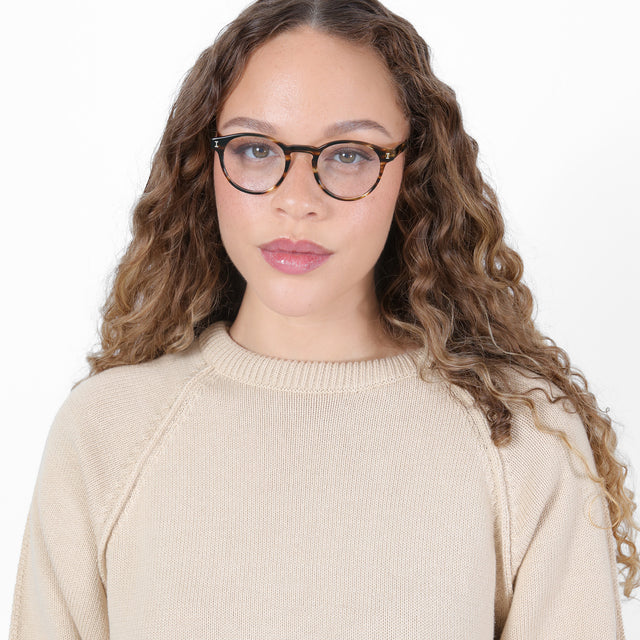 Brunette model with ombré, natural curls wearing Wyoming Optical Dark Sand Optical