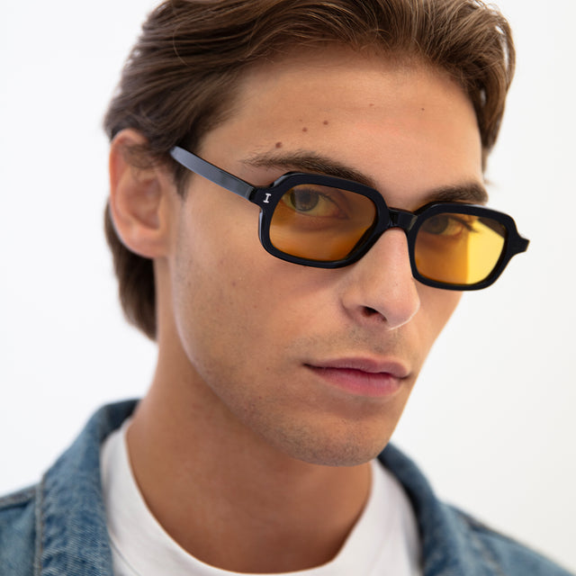 Model with light brown hair combed back wearing Berlin Sunglasses Black with Honey See Through