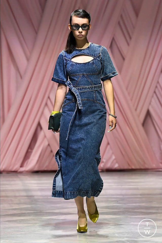 Model wearing a denim dress on a runway wearing Wilson Sunglasses