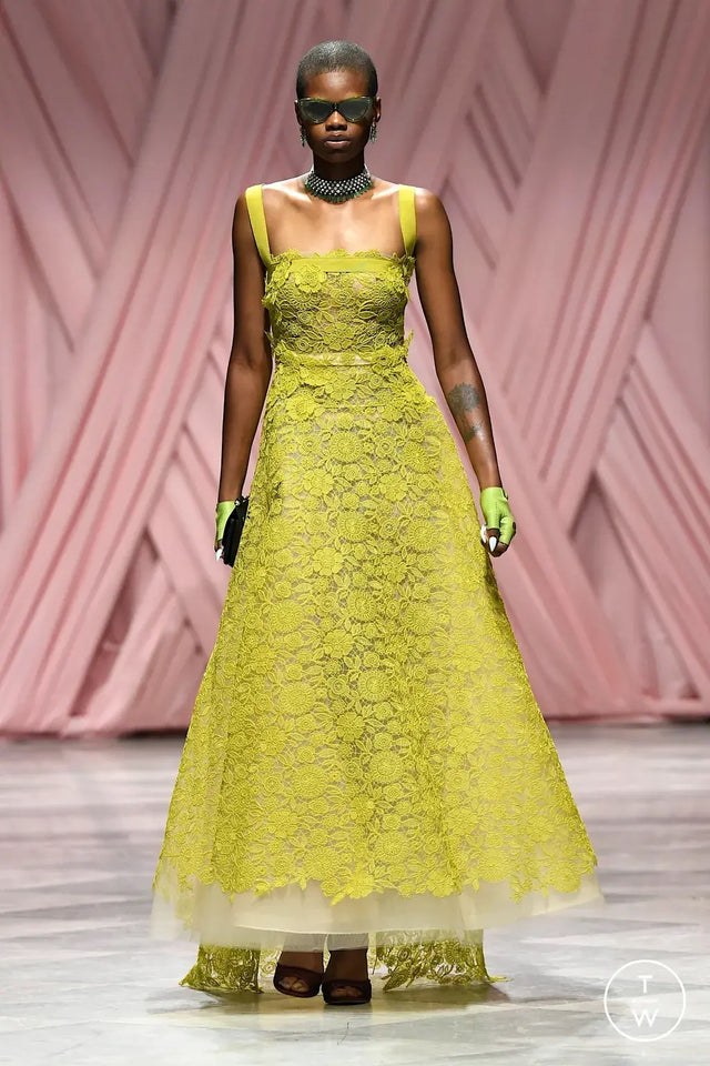 Model wearing a bright yellow lace dress and the Pamela Sunglasses on a runway