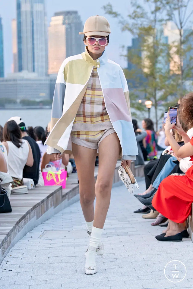 Person in a colorful poncho walking on a catwalk wearing Cynthia Rowley