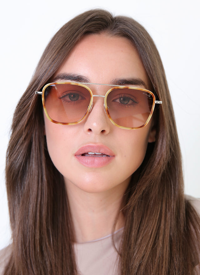 Brunette model wearing Delos Ace Sunglasses Amber/Gold with Brown Flat Gradient