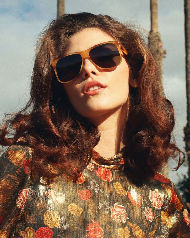 Brunette model in a flower shirt wearing Dionne Sunglasses Caramel Havana with Olive