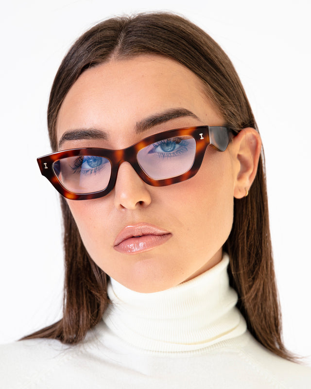 Brunette model in a white turtleneck wearing Donna Optical Havana Optical