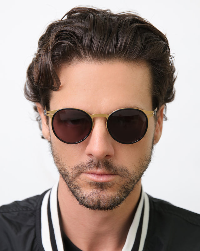 wearing Great Jones Titanium Sunglasses Black/Matte Gold Grey